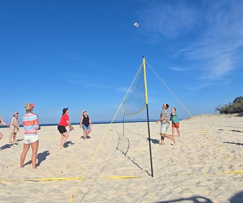 Group playing beach volleyball outdoors.
